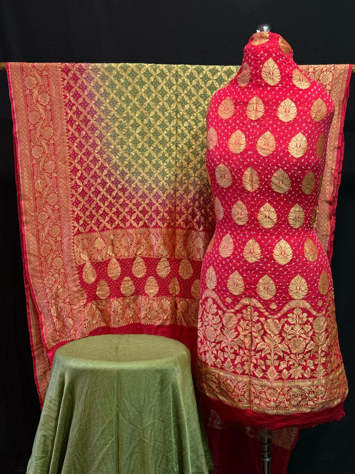 "Red Banarasi suit set with golden zari booti and shaded pink-golden dupatta displayed on mannequin"
