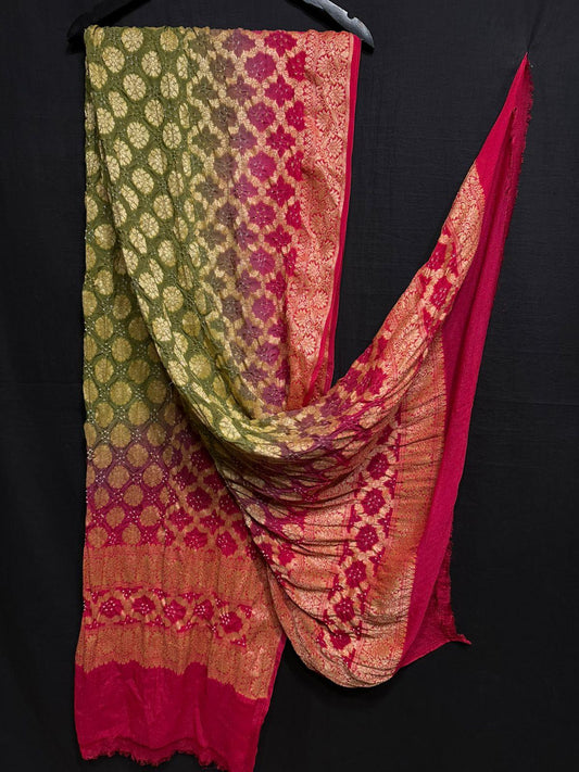 "Banarasi dupatta with multi-tone pink, red and green shades and golden zari weaving hung against black backdrop"